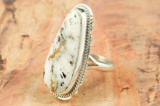White Buffalo Turquoise set in Sterling Silver Ring. This Beautiful Stone is formed from the minerals Calcite and Iron. It is mined near Tonopah Nevada. Created by Navajo Artist Larson Lee. Signed by the artist. 